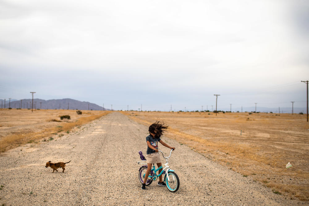 <strong>Salton City, near California's Salton Sea:</strong> Lizette plays on her bicycle as strong winds are blowing across her neighborhood. Little water enters the area and the water that does enter is all agricultural run off laced with pesticides and fertilizers. As the lake shrinks it exposes sand and dust that blows into the air exposing people living nearby to PM10 particulate dust.
