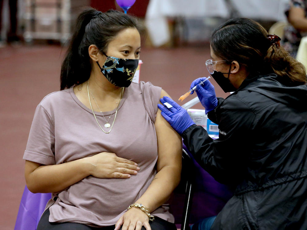 A woman receives a Pfizer vaccination booster shot from a nurse in Los Angeles. California Department of Public Health officials say that no fully vaccinated adult should be denied a COVID-19 booster shot in the state.