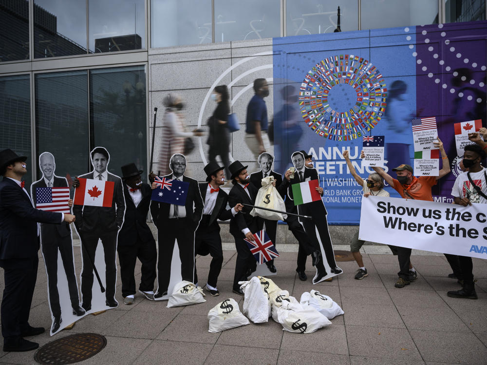 Activists dressed as debt collectors hold cutouts of the leaders of the United States, Canada, Australia, the UK and Italy in front of the International Monetary Fund headquarters in Washington, D.C., last month to ask rich nations to keep their financial commitment to developing countries to tackle climate change.