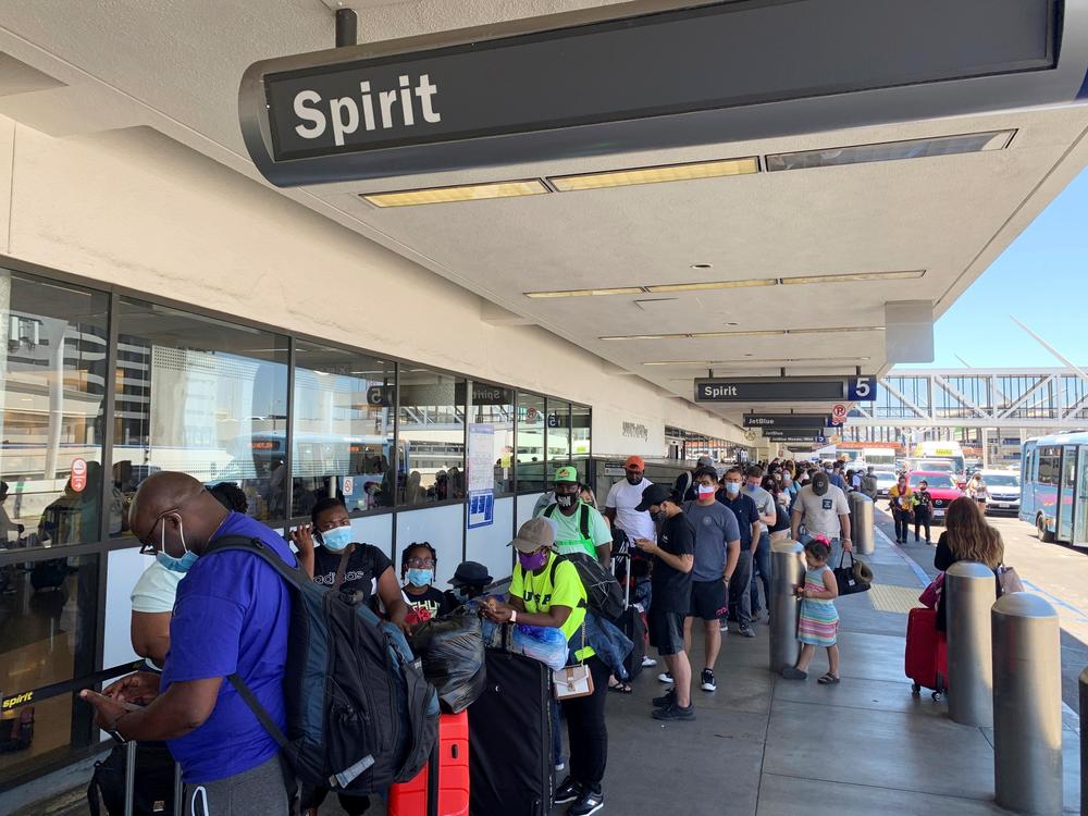 Passengers line up outside the Spirit Airlines terminal at Los Angeles International Airport in Los Angeles on Tuesday, Aug. 3. Spirit Airlines canceled more than half its schedule Tuesday, and American Airlines struggled to recover from weekend storms at its Texas home, stranding thousands of passengers at the height of the summer travel season.