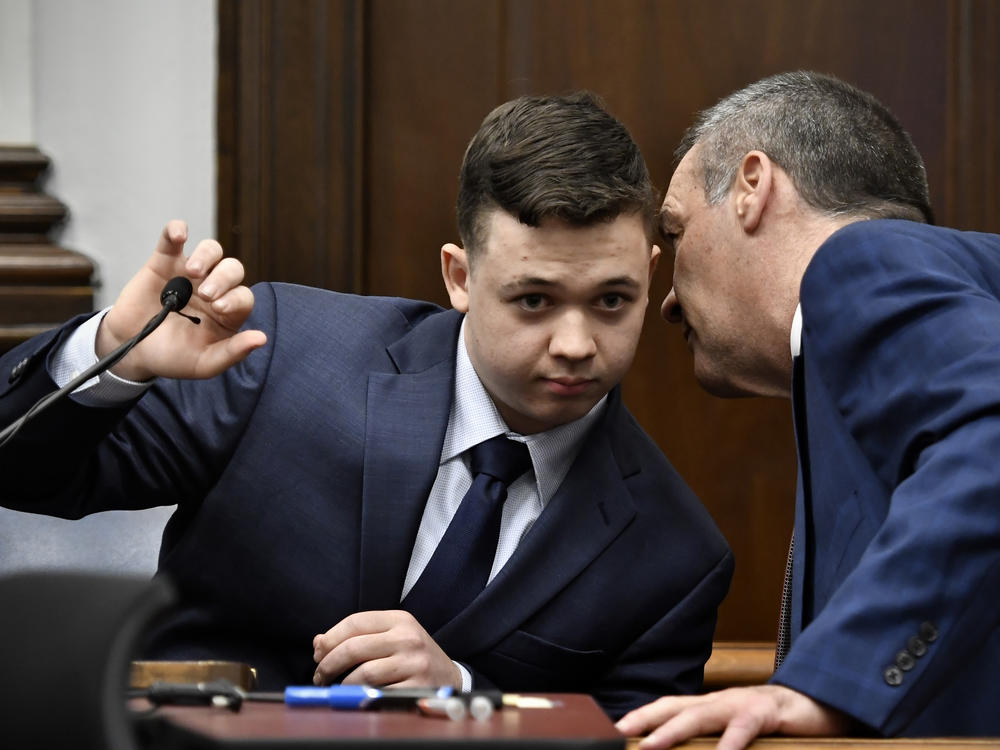 Kyle Rittenhouse (left) listens to his attorney Mark Richards as he takes the stand during his trial on Wednesday in Kenosha, Wis.