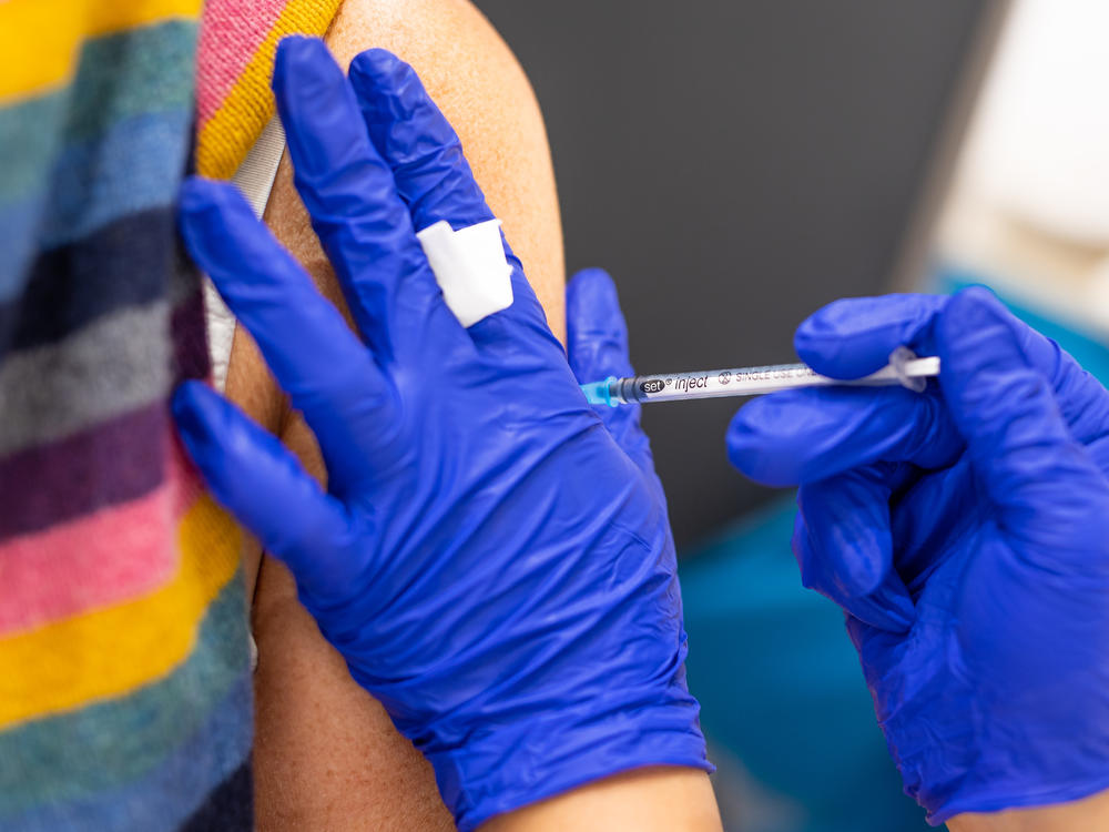 A vaccination center worker inoculates a woman with the Biontech vaccine against Covid-19 in Lower Saxony.