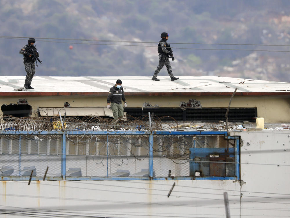 Police walk on the roof of the Litoral Penitentiary on Saturday after riots broke out inside the jail in Guayaquil, Ecuador.