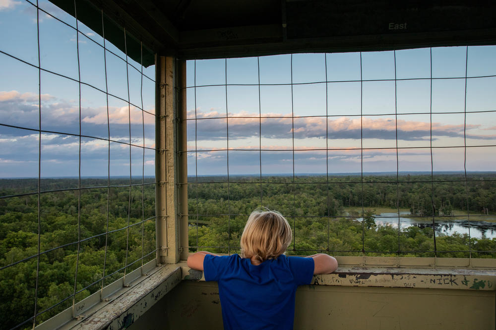Errol Sleeper, 7, takes in the view from the cab of the Aiton Heights Fire Tower in northern Minnesota's Itasca State Park. After climbing to the top of the 100-foot tower, Sleeper officially became a member of the Ancient and Honorable Order of Squirrels, a national fire tower club founded in 1927 by an Itasca Park Ranger to educate youth and adults about fire prevention and forest health.
