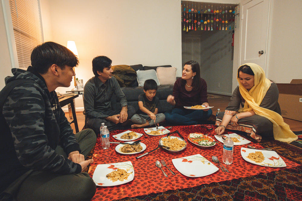 Zahra Yagana (right), family friend Susannah Washburn, Nabil Mahrammi, Hossein Mahrammi, and Jawed Yagana dine on the floor at Zahra Yagana's apartment in Silver Spring, Md.