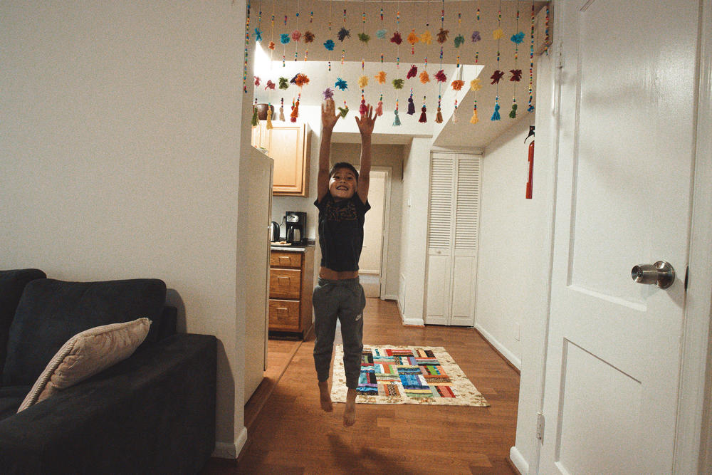 Hossein Mahrammi's youngest son, 6-year-old Nabil, jumps up to play with a decoration that Parisa Yagana made for her family's apartment.