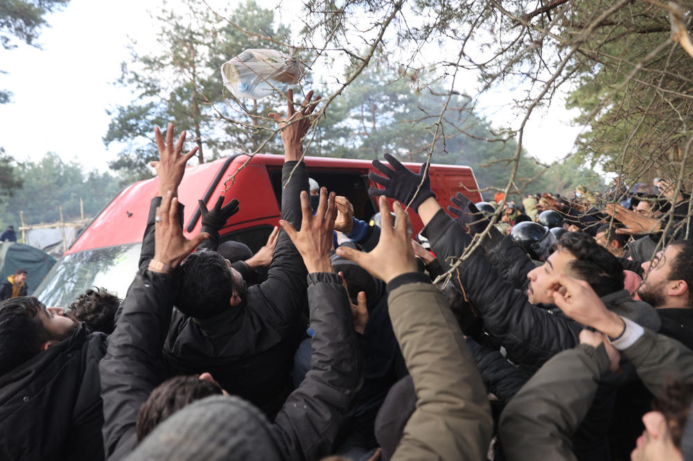 Migrants gather to receive humanitarian aid in a camp on the Belarusian-Polish border in the Grodno region, in Belarus, on Nov. 12. Hundreds of desperate migrants are trapped in freezing temperatures on the border.