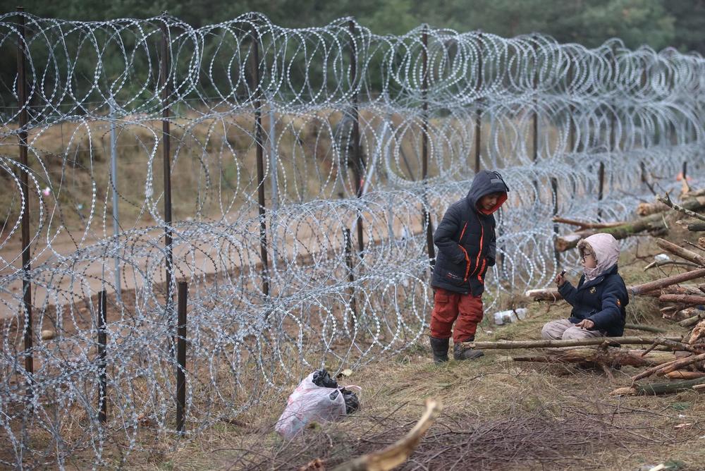 A picture taken on Nov. 12 shows migrants in a camp on the Belarusian-Polish border in Belarus' Grodno region. The presence of troops from both sides has raised fears of a confrontation.