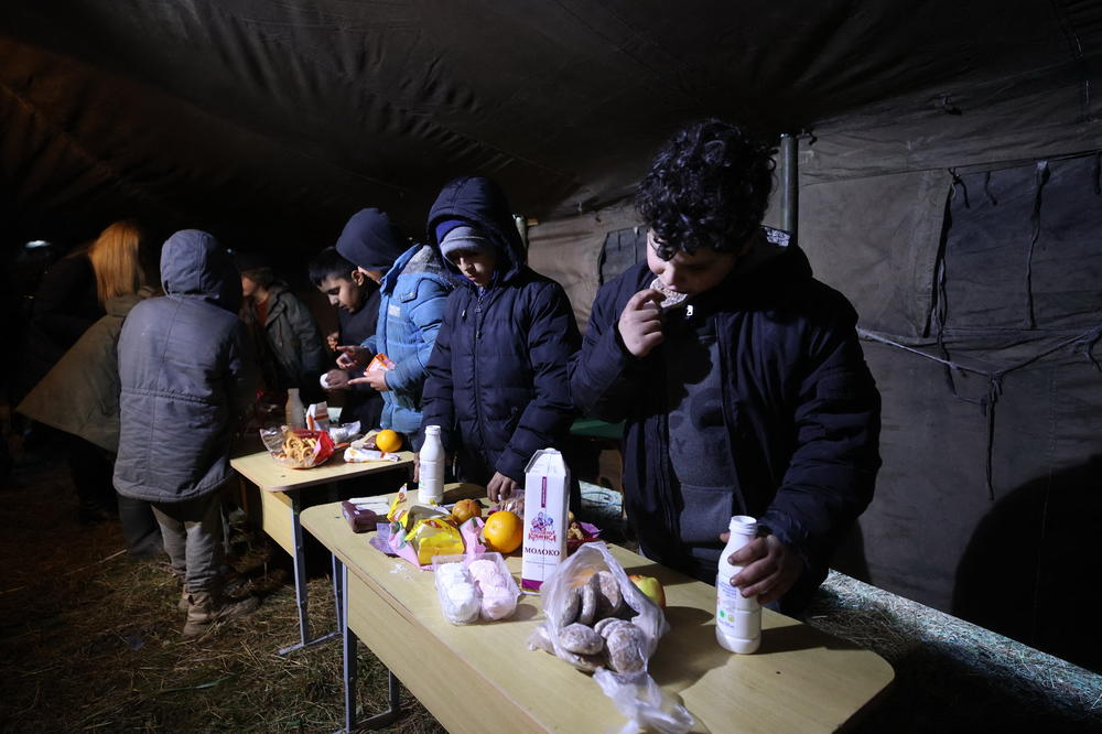 Migrants have a meal in a camp near the Belarusian-Polish border in the Grodno region on Saturday.