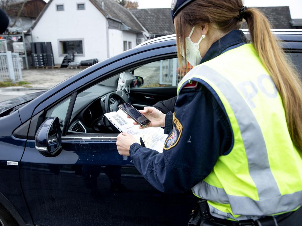 An Austrian police officer checks a driver's vaccination certificate during a traffic control stop in Graz, Austria, on Monday.