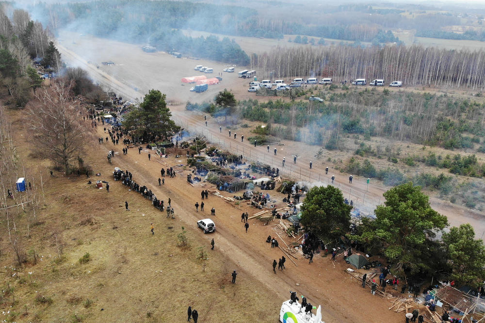 Migrants collect their belongings before leaving a camp in Grodno, Belarus, and heading toward the border crossing into Kuznica, Poland, on Monday.