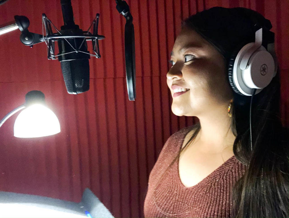 Ravonelle Yazzie in the recording studio playing the part of Marisol, a beautiful young woman who is held captive then freed by Clint Eastwood's mysterious stranger in the Navajo-dubbed version of <em>A Fistful of Dollars</em>.