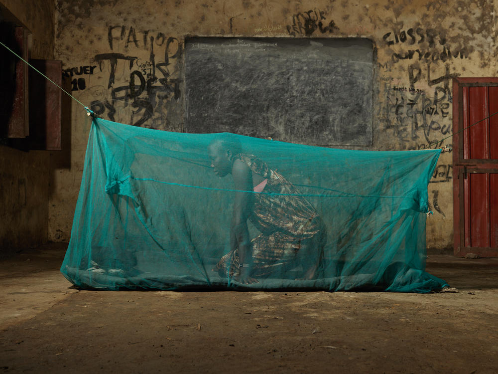 Nyadak Yak, 29, sleeps under a mosquito net in an abandoned classroom. She is one of the lucky few who have found shelter in a place that has not yet been inundated by floodwater.<strong> </strong>