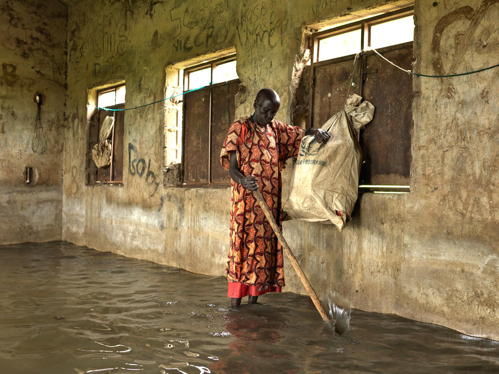 Nyakeak Rambong, 71, stands inside the abandoned school, used as a refuge for villagers displaced by the floods in 2020. 