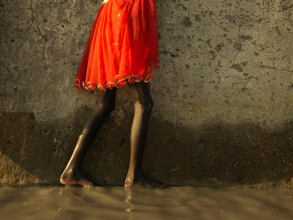 Nyajima Guoy, 5, tries to stay dry by clinging onto a wall. (November 2020)