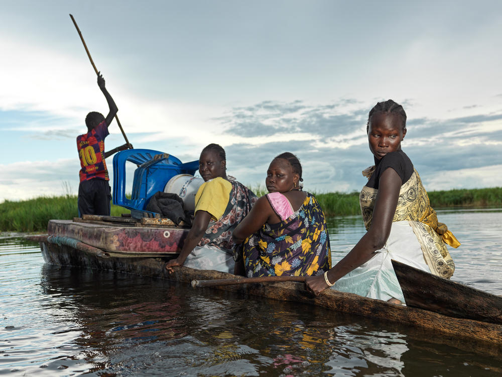 Nyadut Gatkuoth, 30, second from right, sits in a canoe with relatives<strong>. </strong>