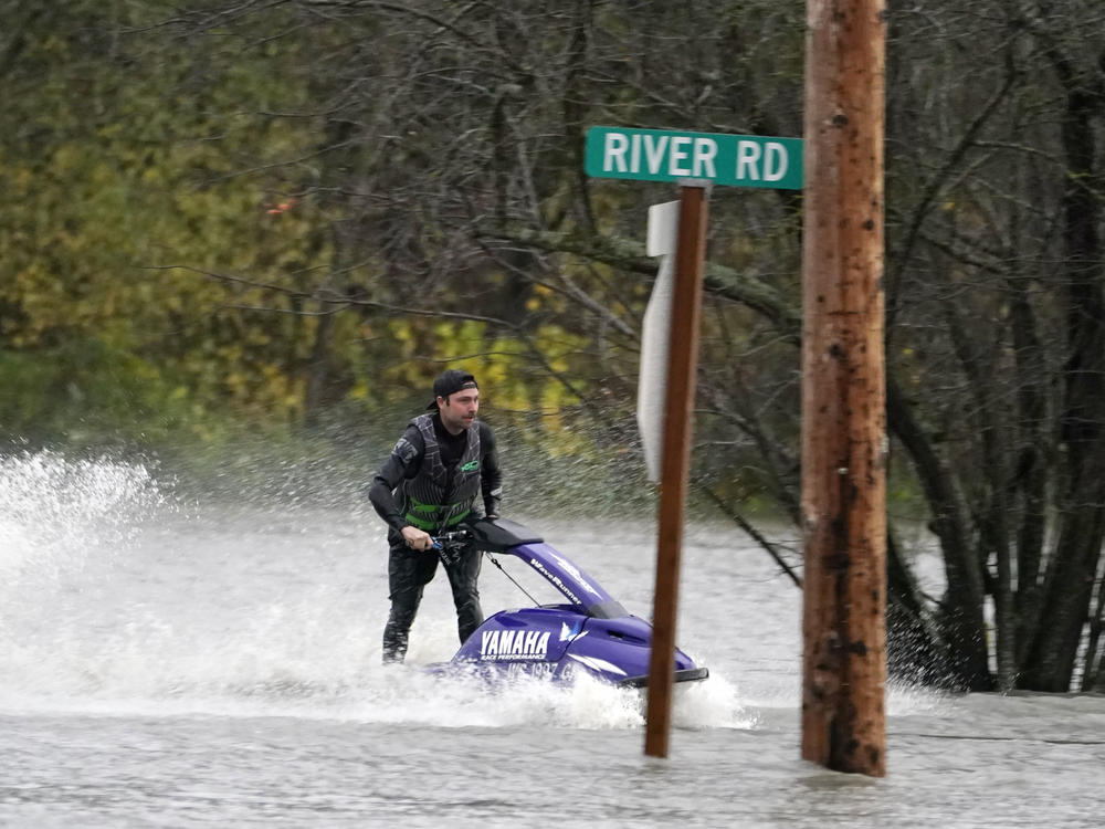 A man operates a personal watercraft along a road flooded by water from the Skagit River on Monday in Sedro-Woolley, Wash.