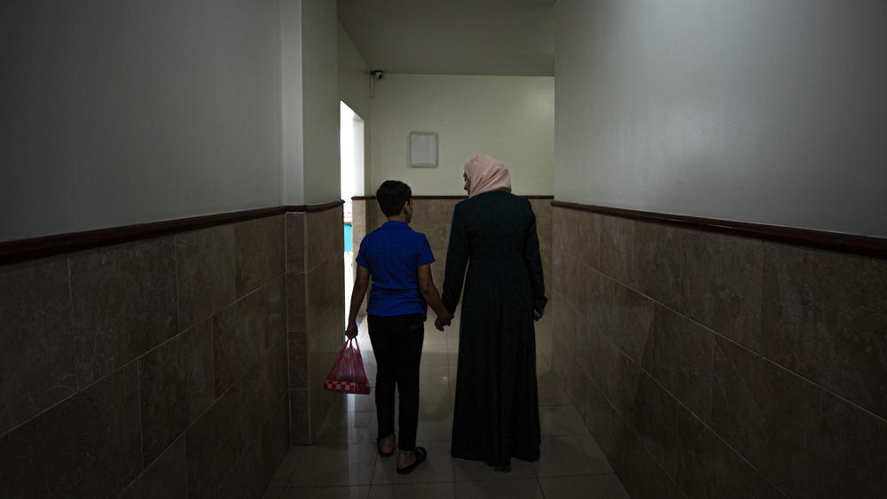 A mental health worker in Gaza walks with one of the children who participated in a psychodrama session aimed to help kids cope with the trauma of war.