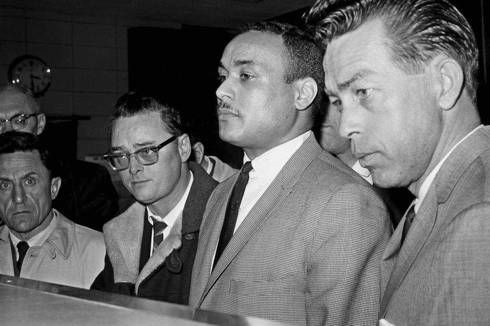 Khalil Islam (center) is booked as the third suspect in the slaying of Malcolm X in New York on March 3, 1965. Islam, previously known as Thomas 15X Johnson, one of two men convicted in the assassination of Malcolm X, was cleared after more than half a century.