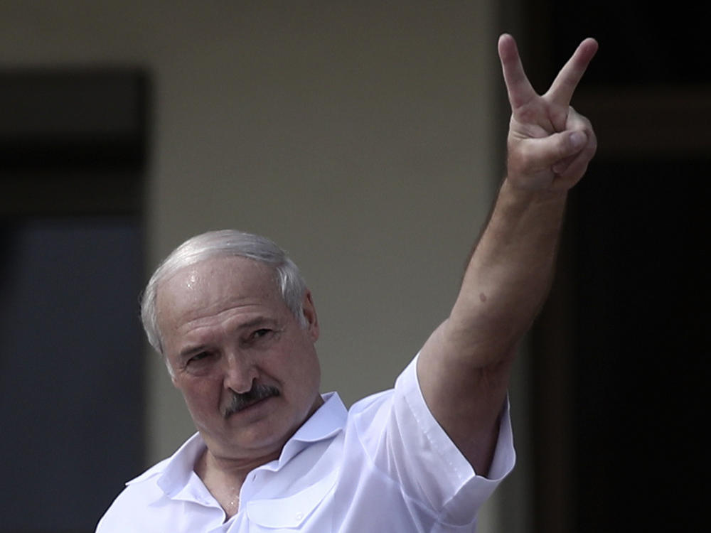 Belarus' President Alexander Lukashenko shows the V-sign during a rally of his supporters in Independence Square last year.