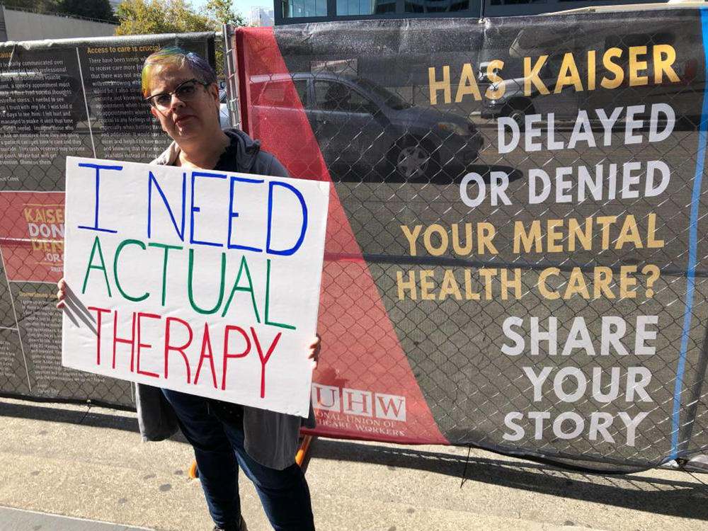 When Greta Christina heard that Kaiser Permanente mental health clinicians were staging a protest on Oct. 13, 2019, over long wait times for therapy, she made her own sign and showed up to support them. She's had to wait up to six weeks between therapy appointments for her depression.