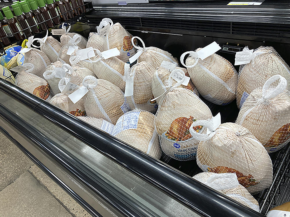 Frozen turkeys sit in a refrigerated case inside a grocery store in southeast Denver. The Farm Bureau says high demand for meat and supply chain woes have increased the cost of Thanksgiving dinner this year.