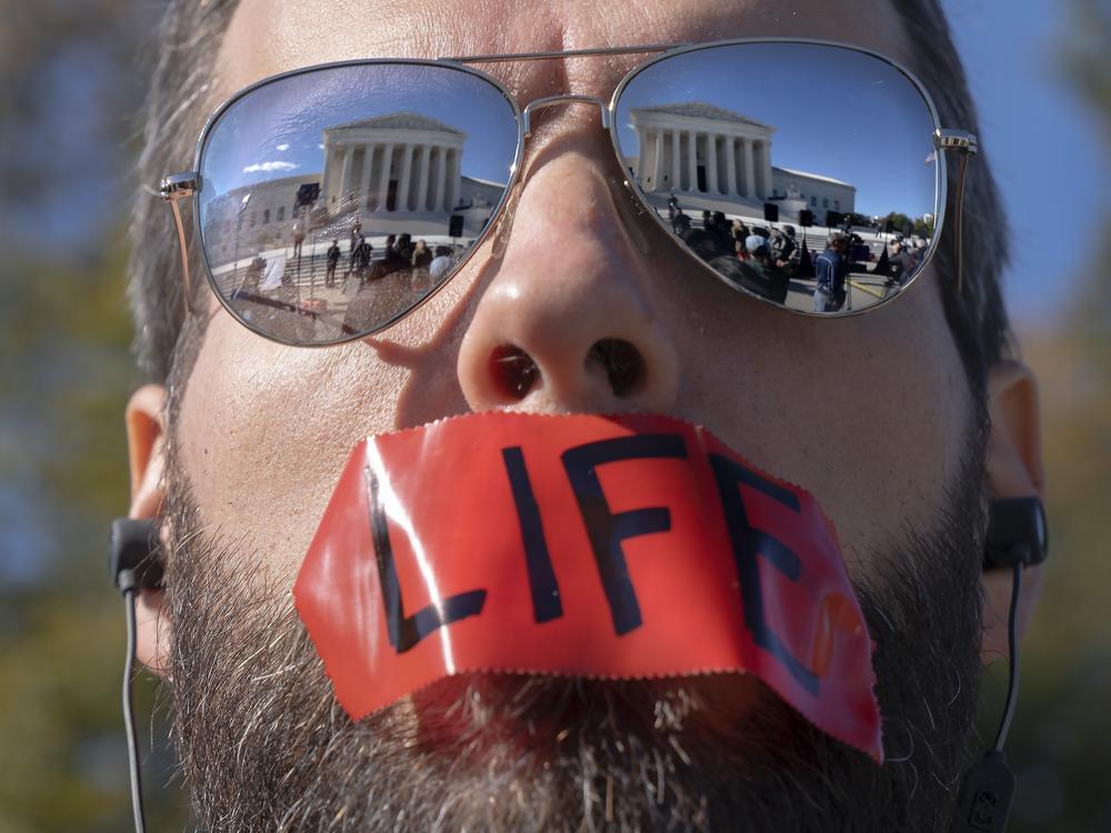 An anti-abortion activist rallies outside the Supreme Court on Nov. 1, as arguments about Texas' abortion law begin. The court has allowed the law to remain in place for now.