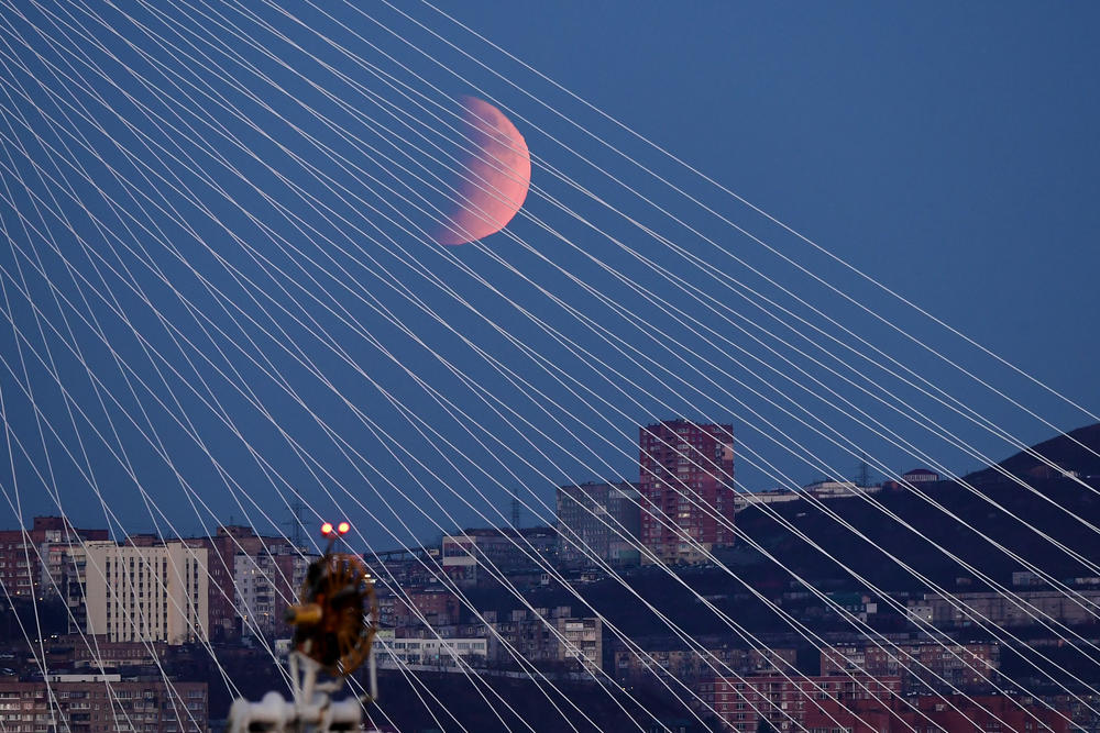 A view of Zolotoy Bridge during a partial lunar eclipse visible over the bay of Zolotoy Rog in Russia.