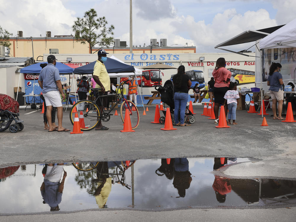 People line up to receive a rapid COVID-19 test in an agricultural community in Immokalee, Fla., where the poverty rate is over 40%. Partners in Health is working with the Coalition of Immokalee Workers to test, educate and vaccinate the community during the pandemic.