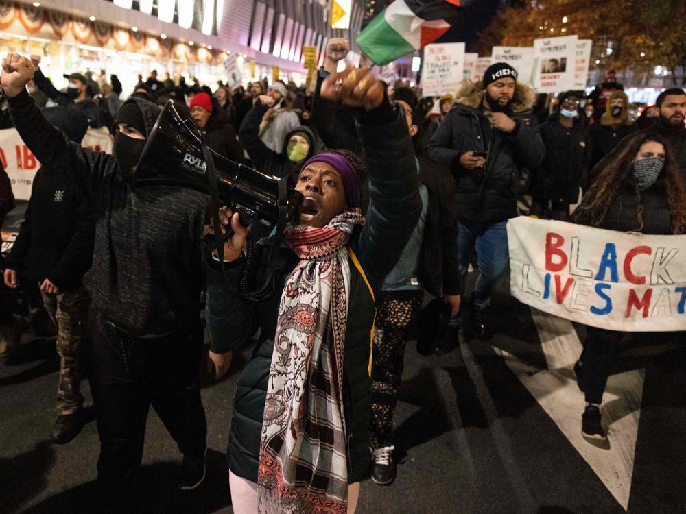 A demonstrator raises her fist while marching on the street during a protest against the Kyle Rittenhouse not-guilty verdict near the Barclays Center in New York City on Friday.