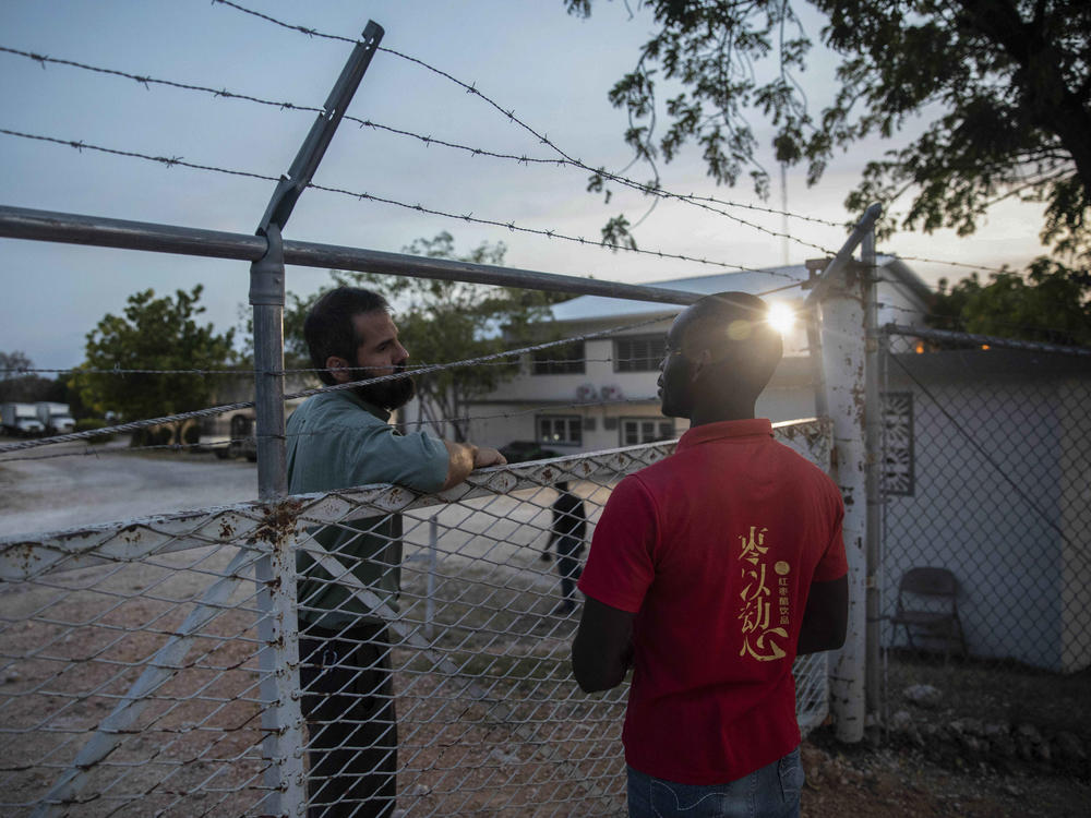A manager at the Christian Aid Ministries headquarters, left, speaks with a worker at the door of the center in Titanyen, north of Port-au-Prince, Haiti, on Sunday.