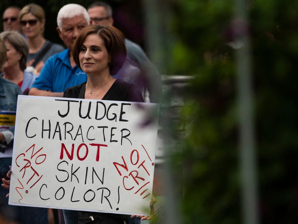 A woman holds up a sign during a rally against 