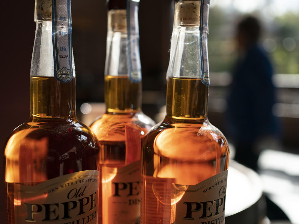 A woman walks past a display of bottles of whiskey at the James E. Pepper Distillery.