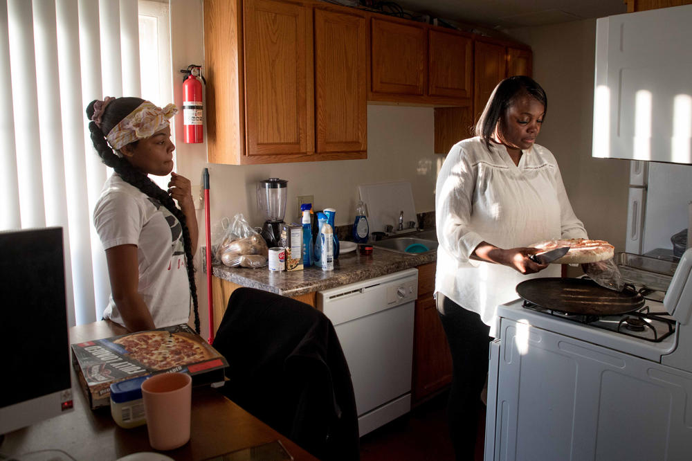 Maryanne Lundy, (right) prepares a pizza while talking with her daughter, Malaysia Hill, at their home on Friday, Nov. 19 in Indianapolis.