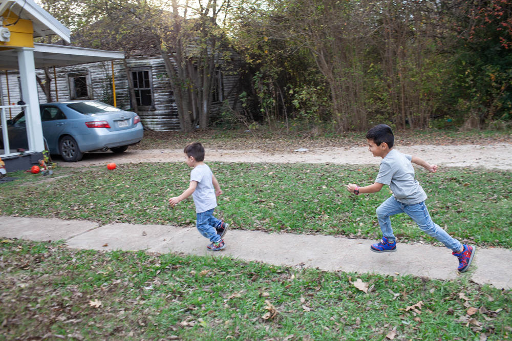 Arion, 5, chases Azaiah, 2, Sunday, November 21, 2021 in the front yard of the house that their family moved into in May of 2021.