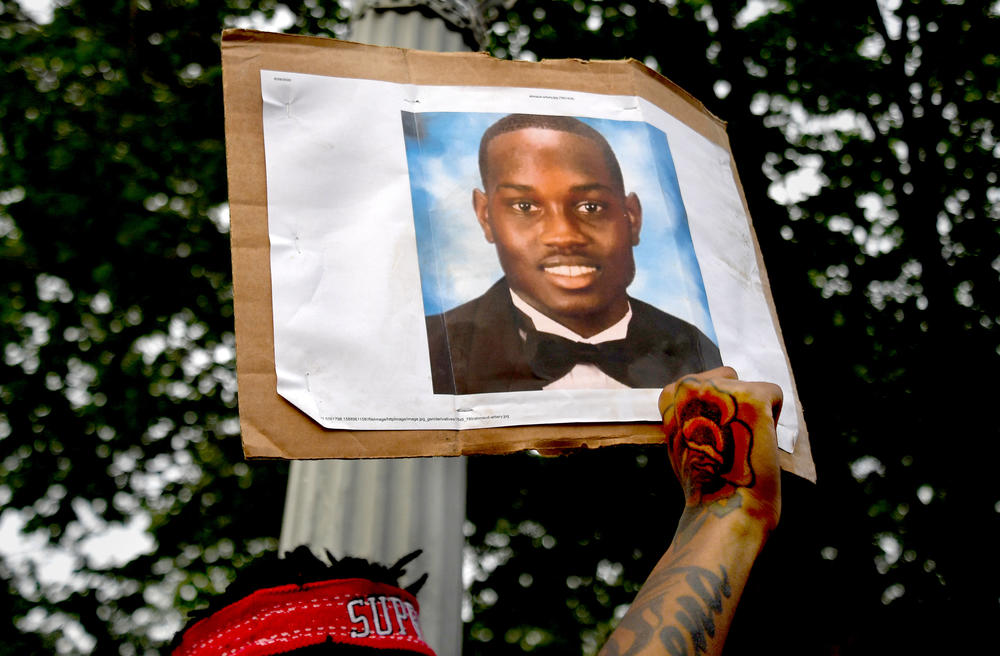 A person protesting racial injustice holds a photo of Ahmaud Arbery during a May 2020 march in Washington, D.C.