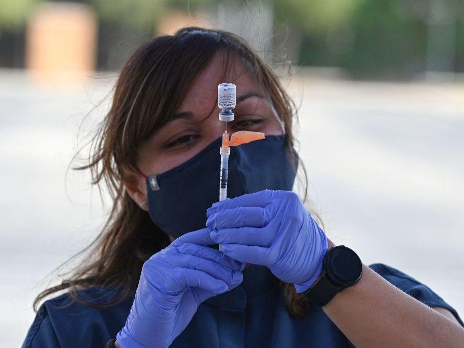 Booster shots are authorized for all U.S. adults, but some are wondering if they need them. A nurse fills a syringe with a Pfizer-BioNTech dose at a pop-up vaccine clinic in the Arleta neighborhood of Los Angeles.