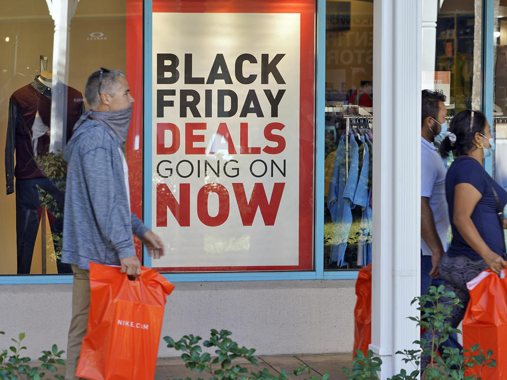 Shoppers wear protective face masks as they look for Black Friday deals at the Ellenton Premium Outlet stores Friday, Nov. 27, 2020, in Ellenton, Fla.