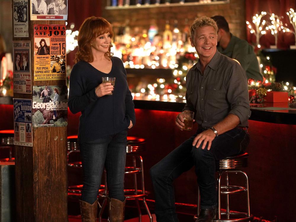 Reba McEntire and John Schneider in <em>Reba McEntire's Christmas In Tune. </em>