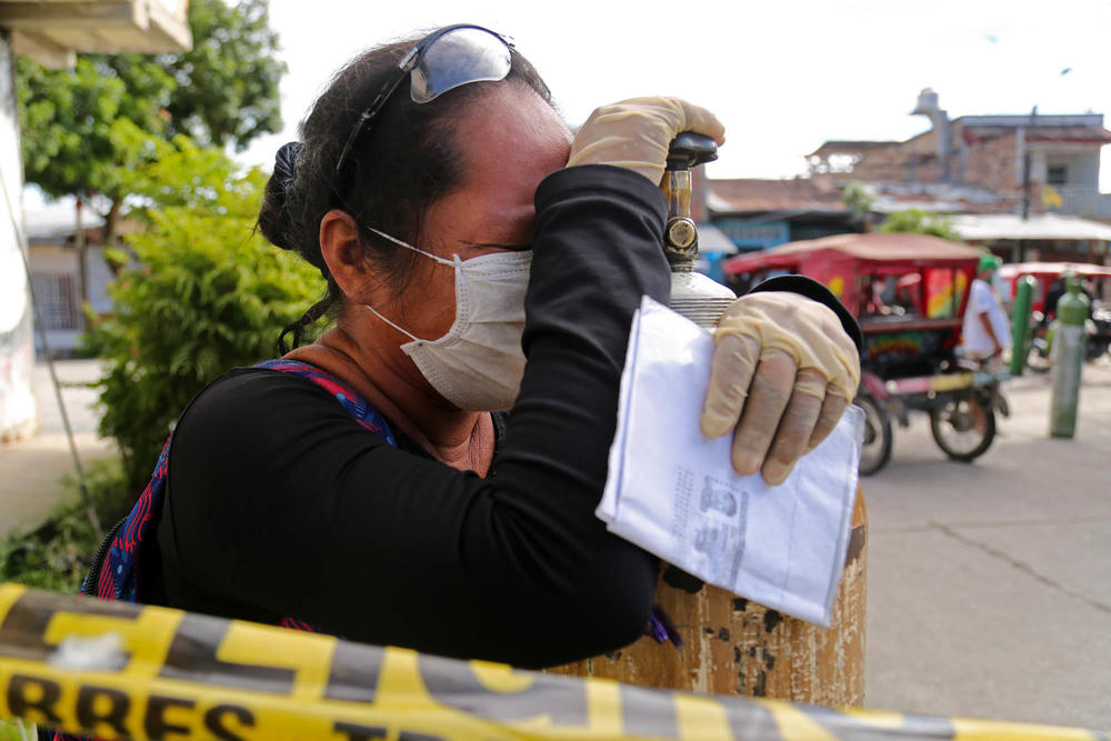 A relative of a COVID-19 patient waits to try to refill a medical oxygen tank in Iquitos in mid-May of 2020. The main oxygen plant in the city broke down days earlier leading to a surge in COVID deaths.