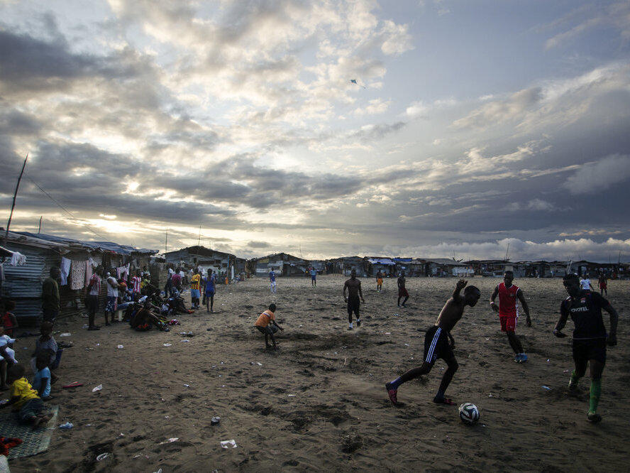 Thanksgiving is a day at the beach — quite literally — for young Liberians. Above, the beach in West Point is a sandy playing field for soccer lovers.