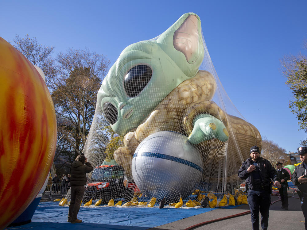 Police walk by an inflated helium balloon of Grogu, also known as Baby Yoda, from the Star Wars show The Mandalorian, on Wednesday in New York, as the balloon is readied for the Macy's Thanksgiving Day Parade on Thursday.