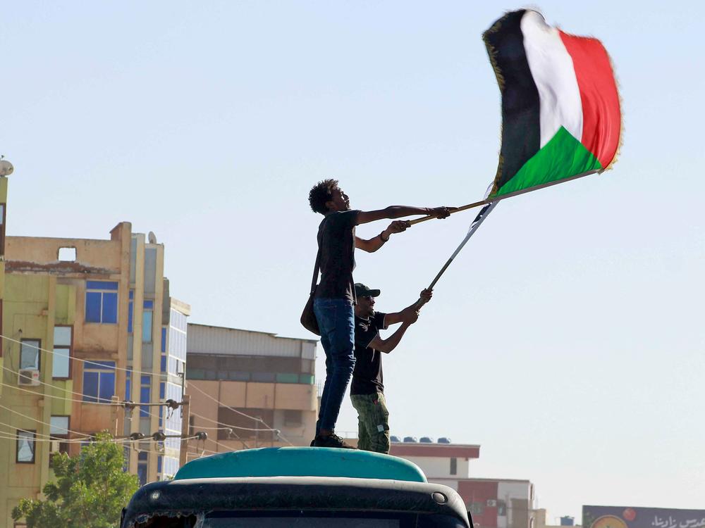 Sudanese anti-coup protesters wave the national flag during a demonstration in the Khartoum-Bahri neighbourhood of the capital, on November 25, 2021.