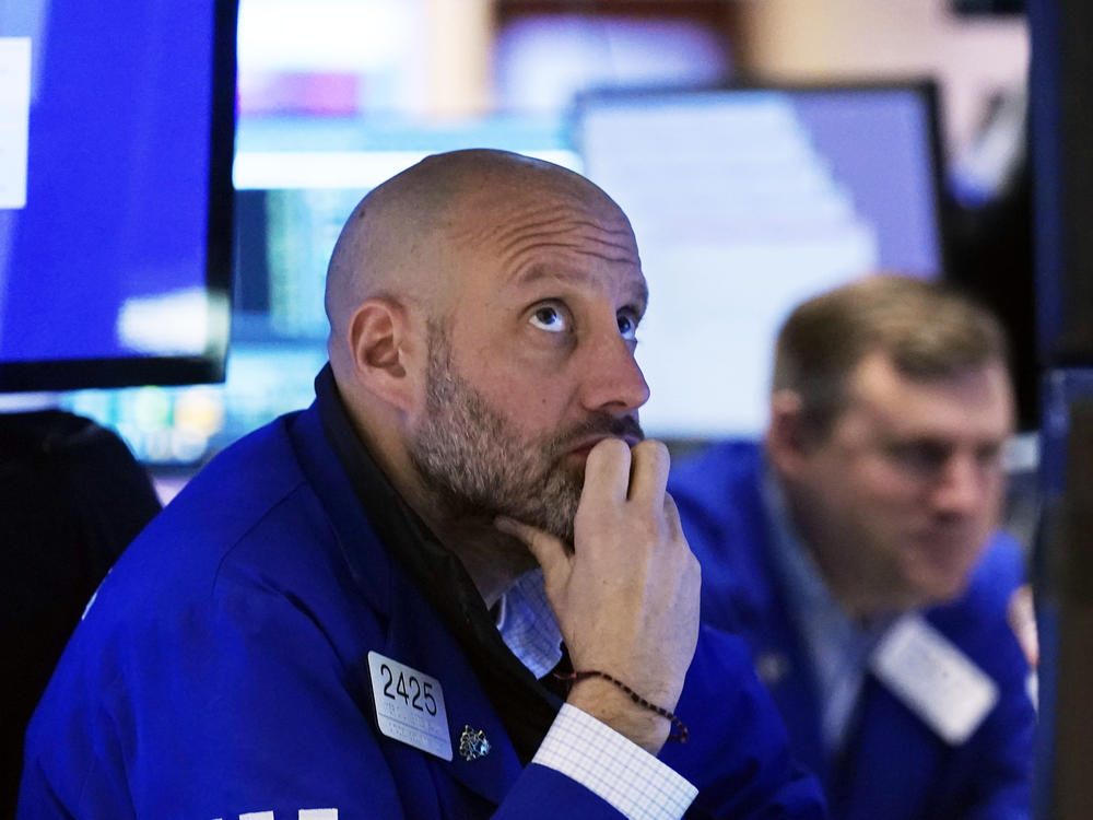 Specialist Meric Greenbaum, left, works at his post on the floor of the New York Stock Exchange on Black Friday. Stocks dropped after a coronavirus variant appears to be spreading across the globe.