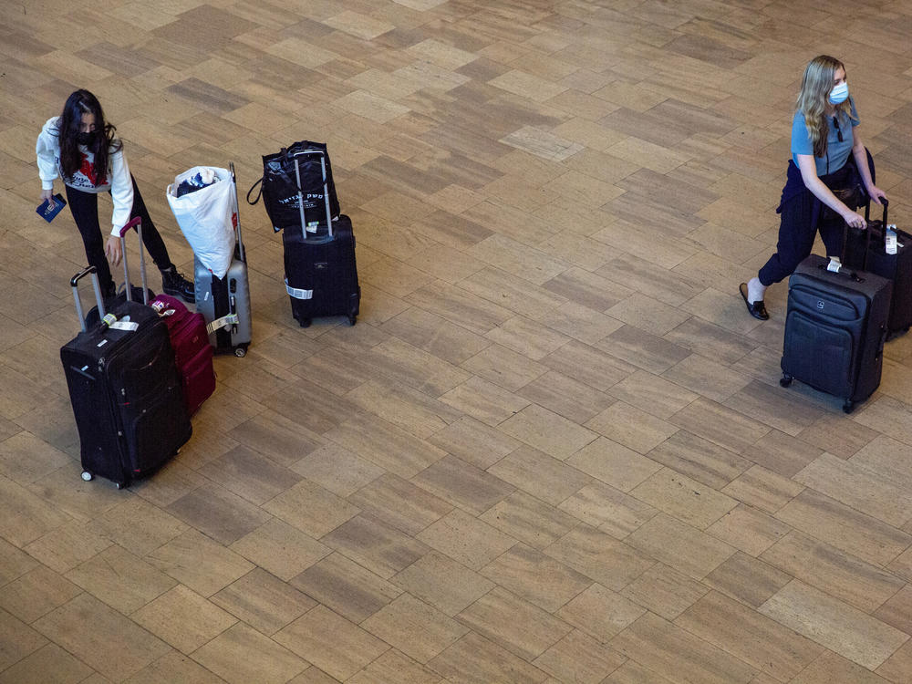 Travelers wearing protective face masks arrive to Ben Gurion Airport near Tel Aviv, Israel on Sunday. Israel on Sunday approved barring entry to foreign nationals as part of its efforts to clamp down on a new coronavirus variant.