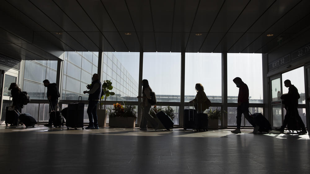 Travelers walk with their luggage in the Ben Gurion Airport near Tel Aviv, Israel on Sunday.