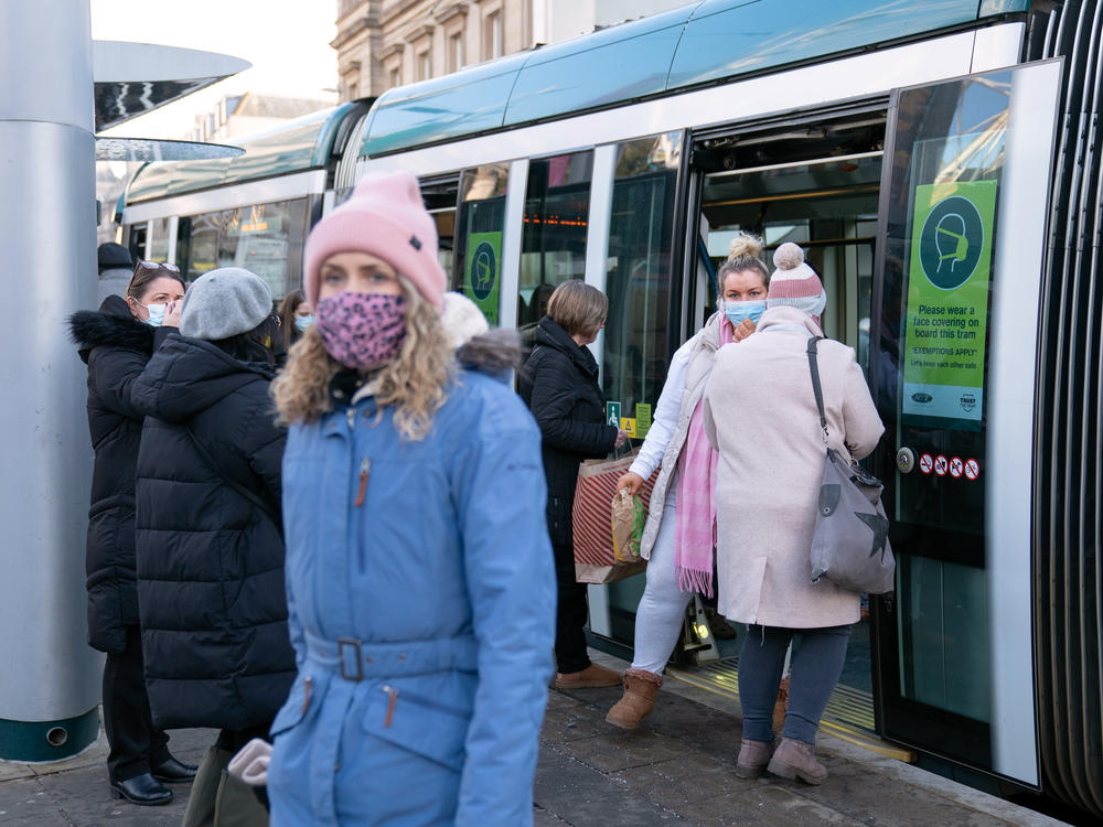 People step off a tram in Nottingham, England, a city where a case of the omicron variant of the coronavirus was identified last week.