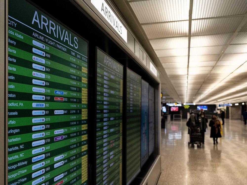 Travelers exit the International Arrivals area at Dulles International Airport in Dulles, Virginia, on Monday. The Biden administration is banning travel for non-U.S. citizens from several African countries over concerns about the omicron variant.