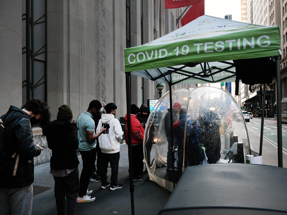 People line up to get tested for COVID at a site in New York City on Monday. The new omicron variant, first detected in South Africa, is quickly spreading around the world.