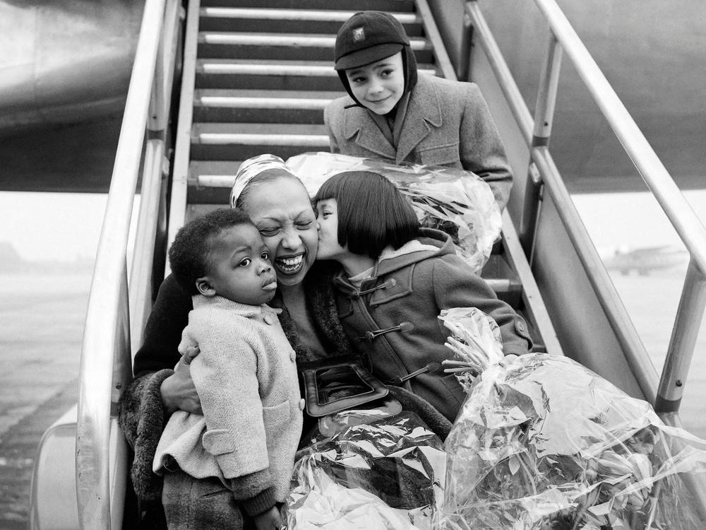 Josephine Baker is welcomed by three of her children after a tour in 1956, at Le Bourget airport near Paris.